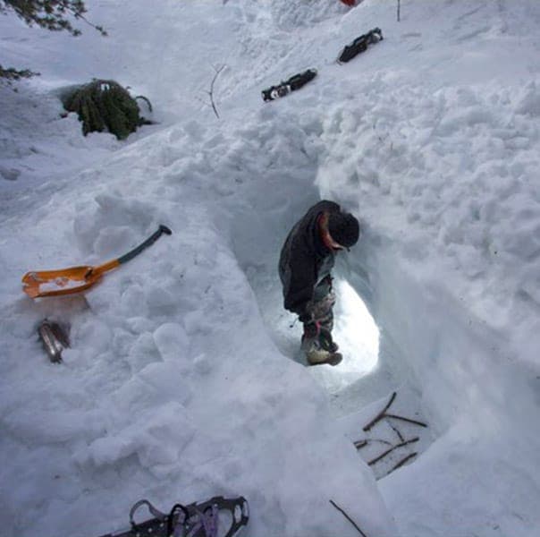 Camper building snow cave